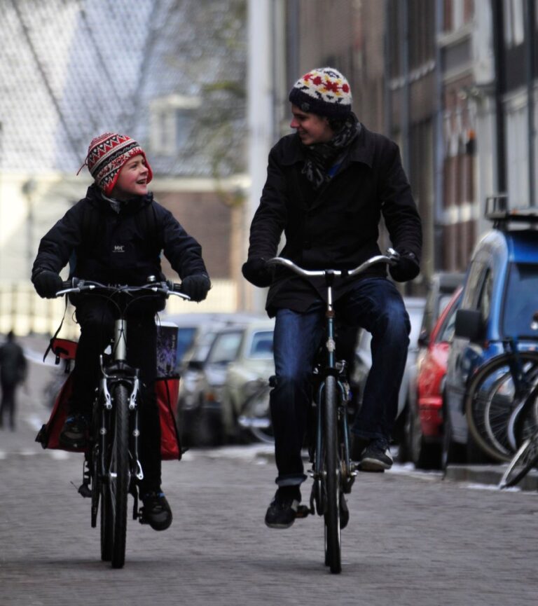 Two brothers cycling. Cycling happens year-round in Amsterdam, with good infrastructure and relationships between bicyclists and motorists.